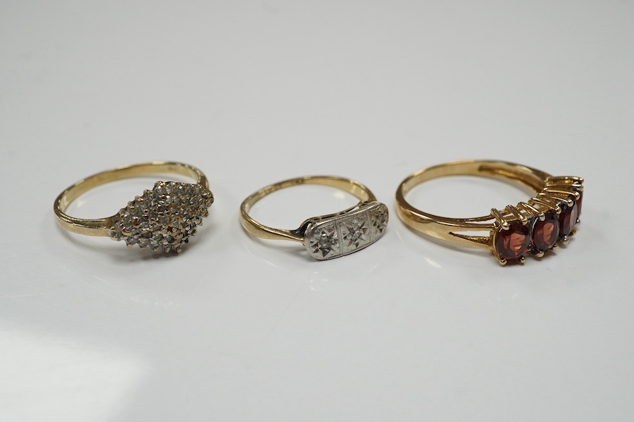 Three assorted 9ct and gem set rings, including three stone diamond, diamond chip cluster and garnet and diamond half hoop, gross weight 6.3 grams. Condition - fair